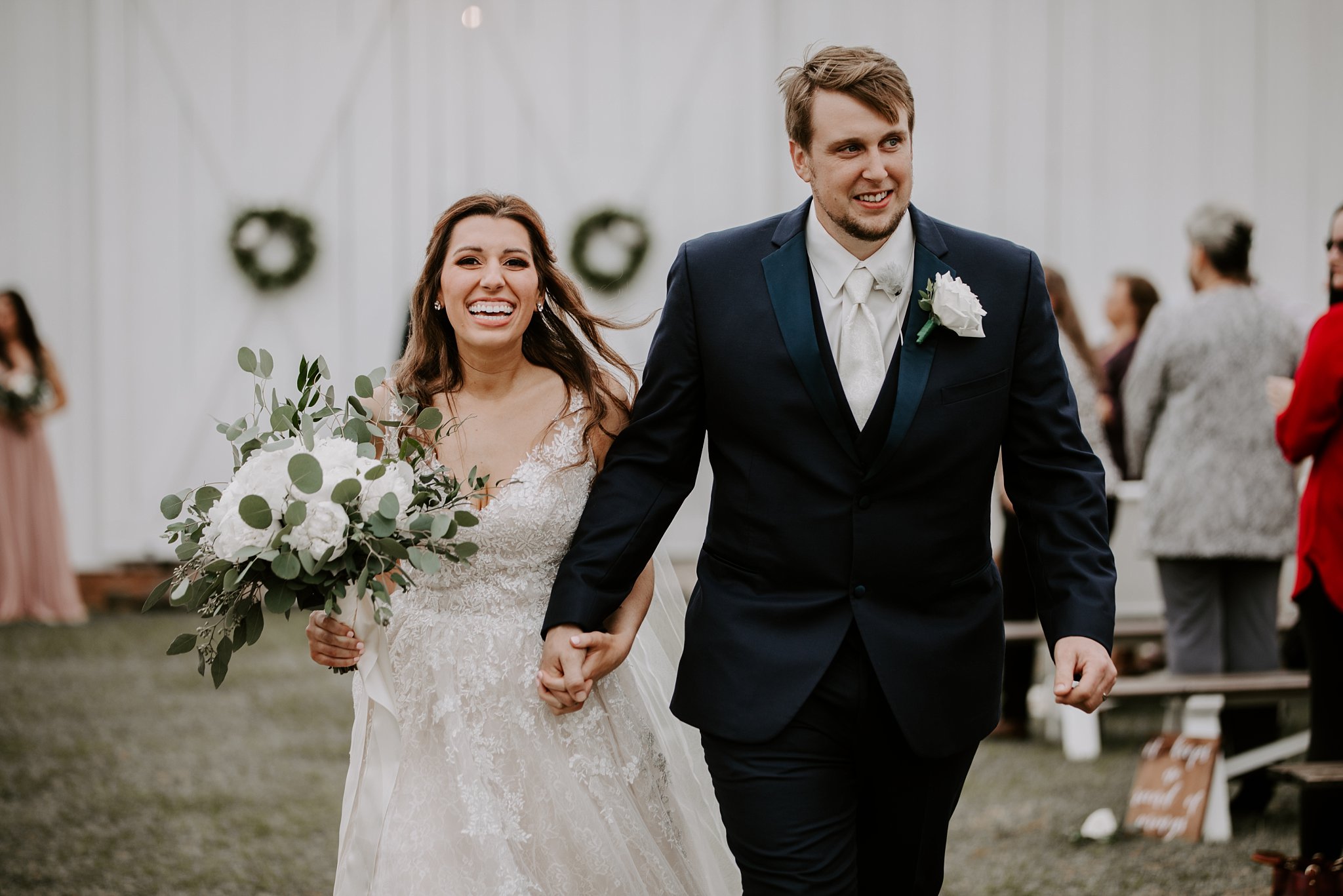 bride and groom can't stop smiling as they walk up the aisle after their wedding ceremony at Rosie Creek Farms