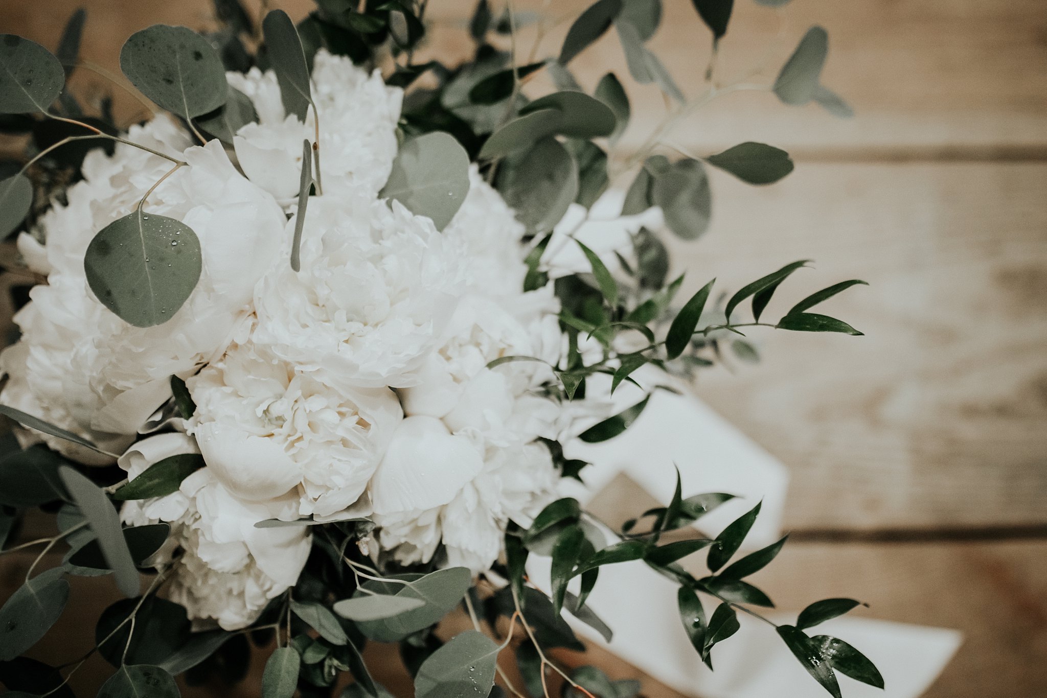 White bridal bouquet with greenery dispersed throughout