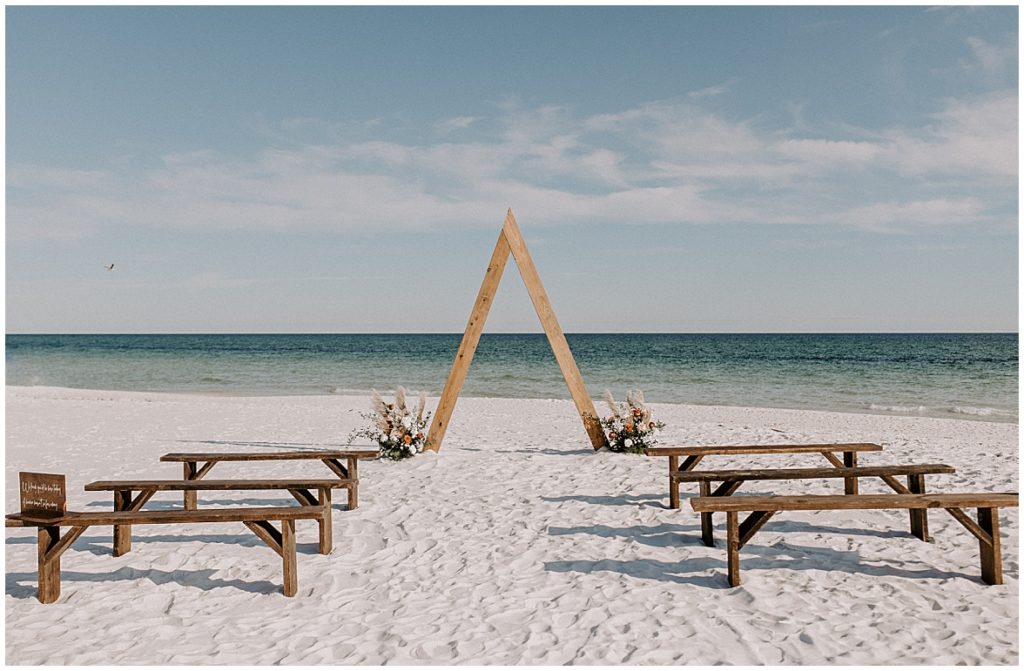 Wide shot of triangular wedding arch with benches 