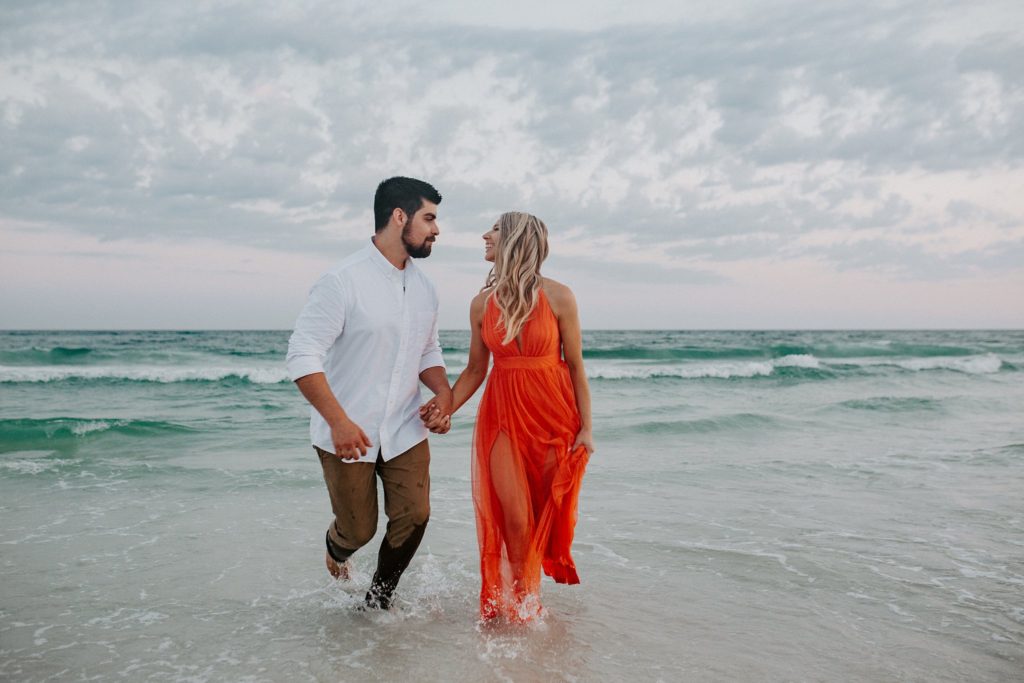 what to do after getting engaged man and woman running on the beach