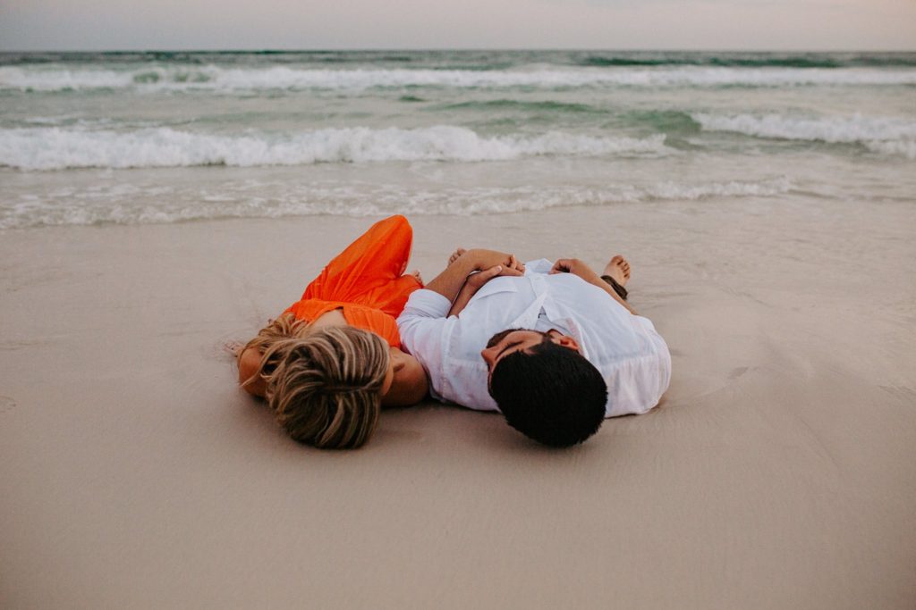 what to do after getting engaged man and woman laying on the beach