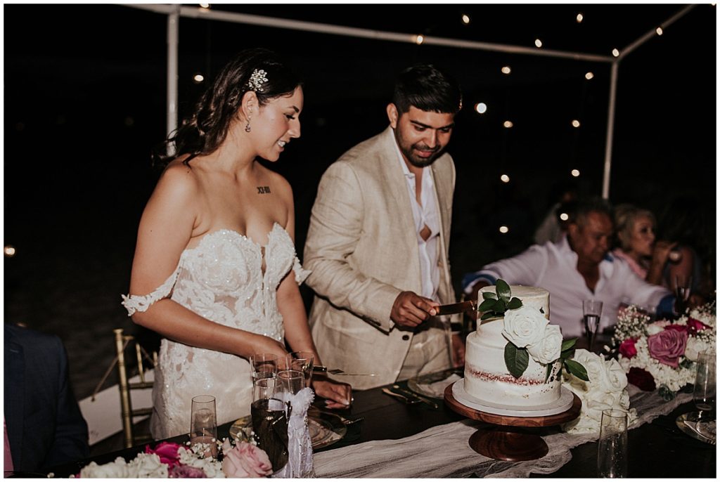 Bride and groom are cutting the cake at their wedding reception