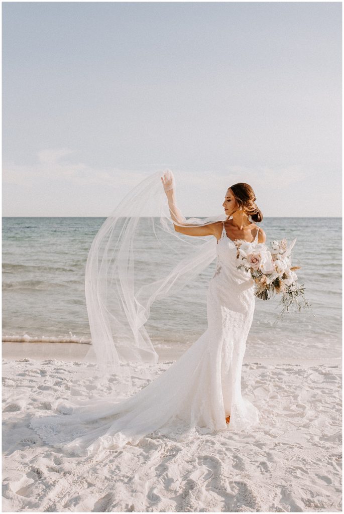 Bride poses with her veil flowing in the wind