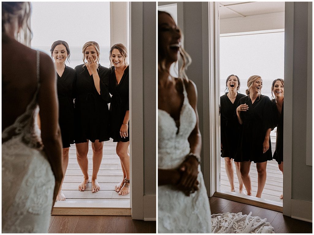 Bridesmaids have first look at the bride all dressed up. They're standing in the doorway and looking into the room