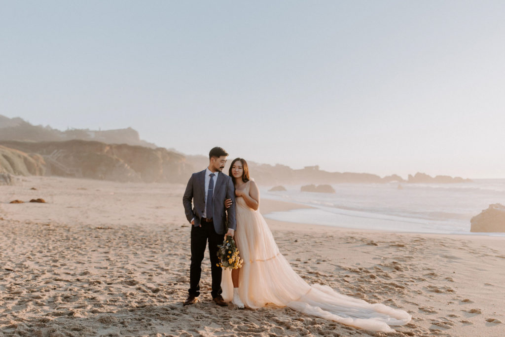 After deciding to elope, this couple is standing on the beach celebrating their adventurous day!