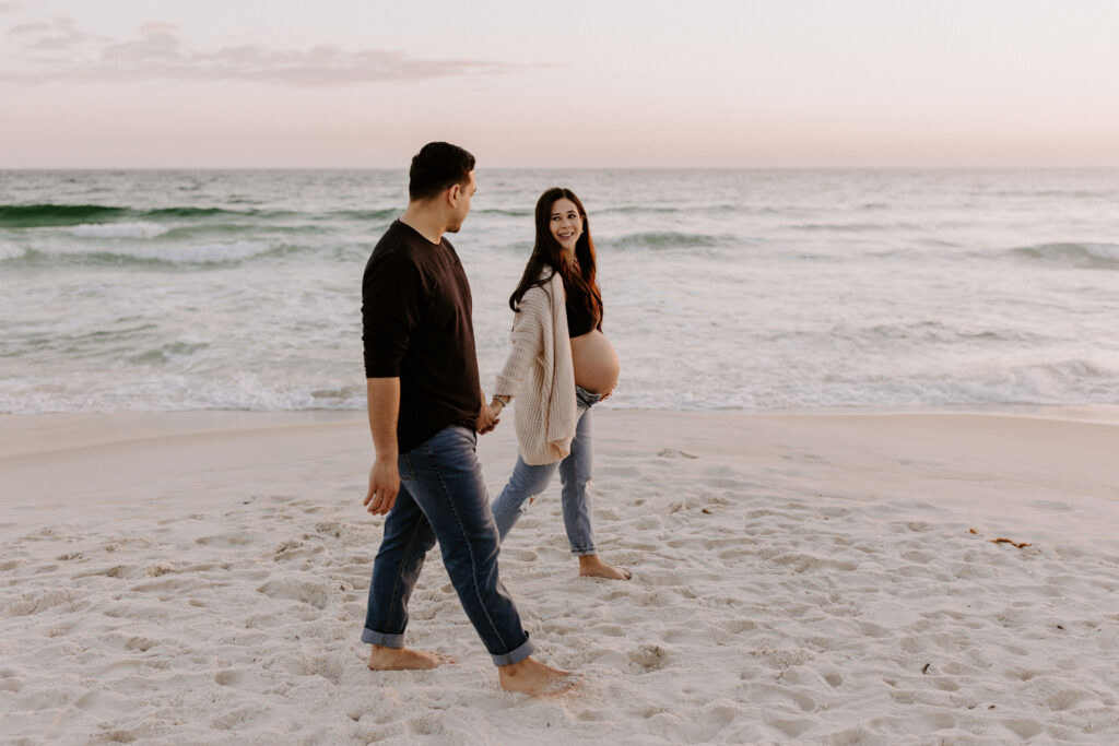 Couple walking on the beach during their destin maternity session