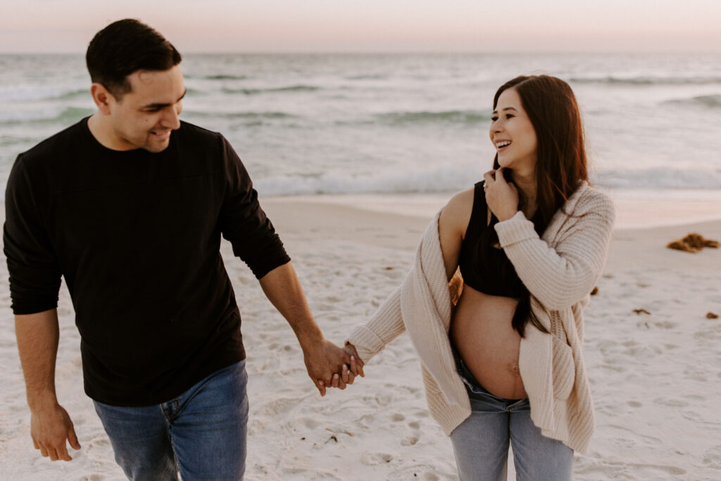 Couple walking on the beach during their destin maternity session