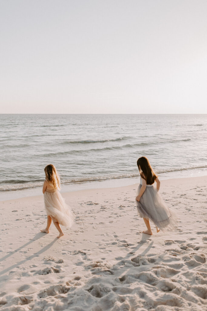 two little girls running to the water on the beach