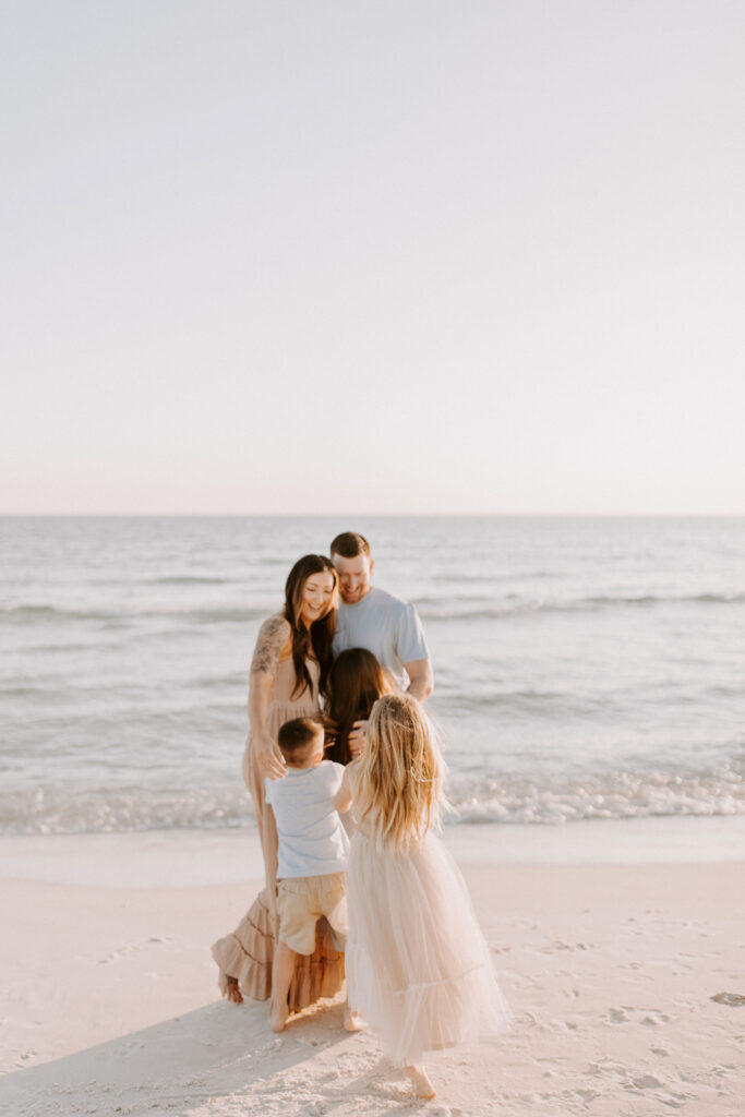 Children running towards mom and dad on the beach during their sunnyside photography session