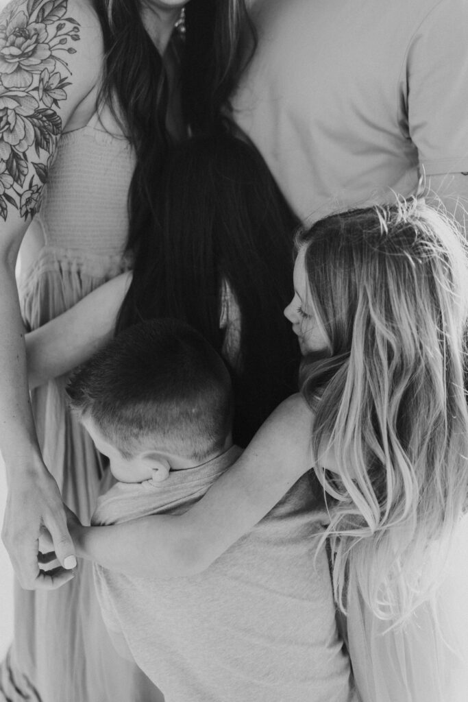 Black and white photo of family hugging during their sunnyside photography session